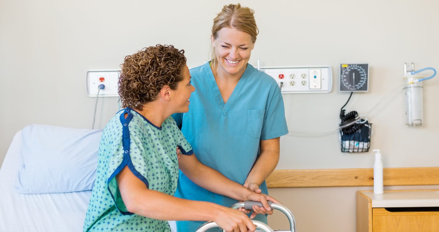 A nurse supporting an older patient